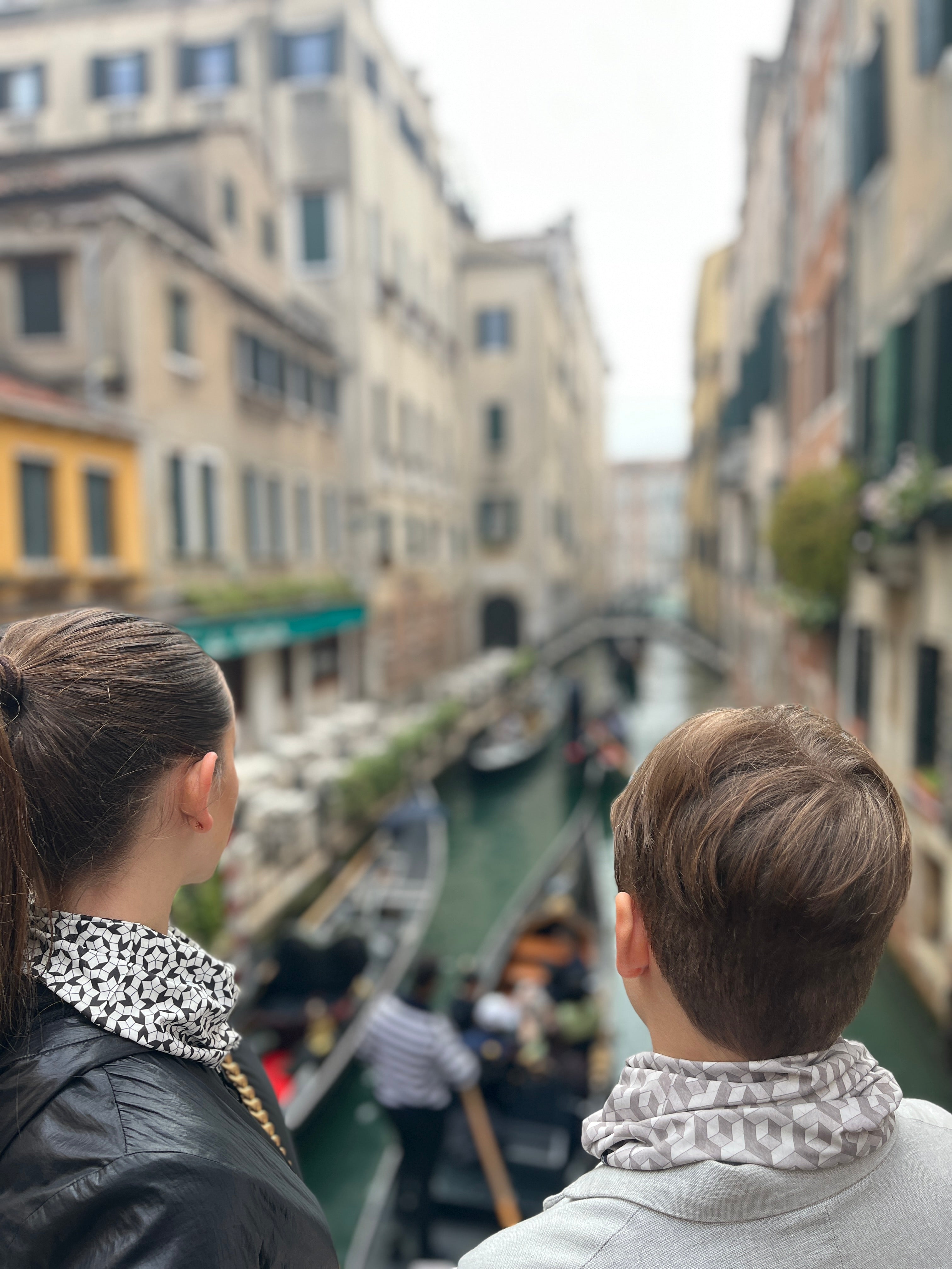 boy and girl looking canal in venice and wearing geometric elegant neckwear