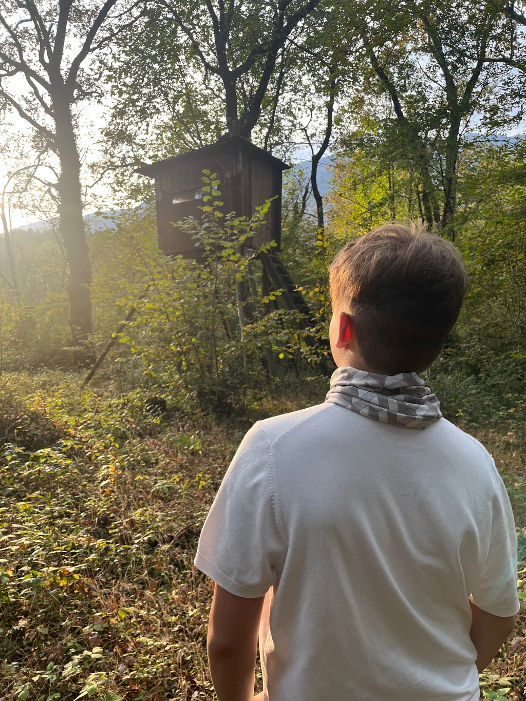 boy wearing geometric neckwear in the woods